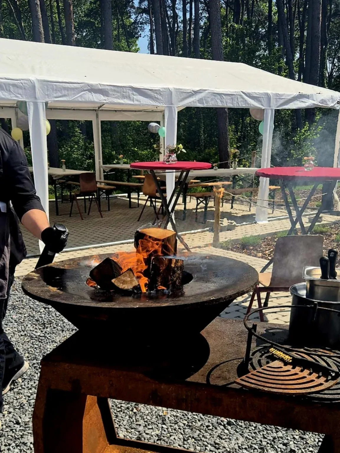 Ofyr met vlees op het festivalterrein, met witte partytenten en tafels op de achtergrond
