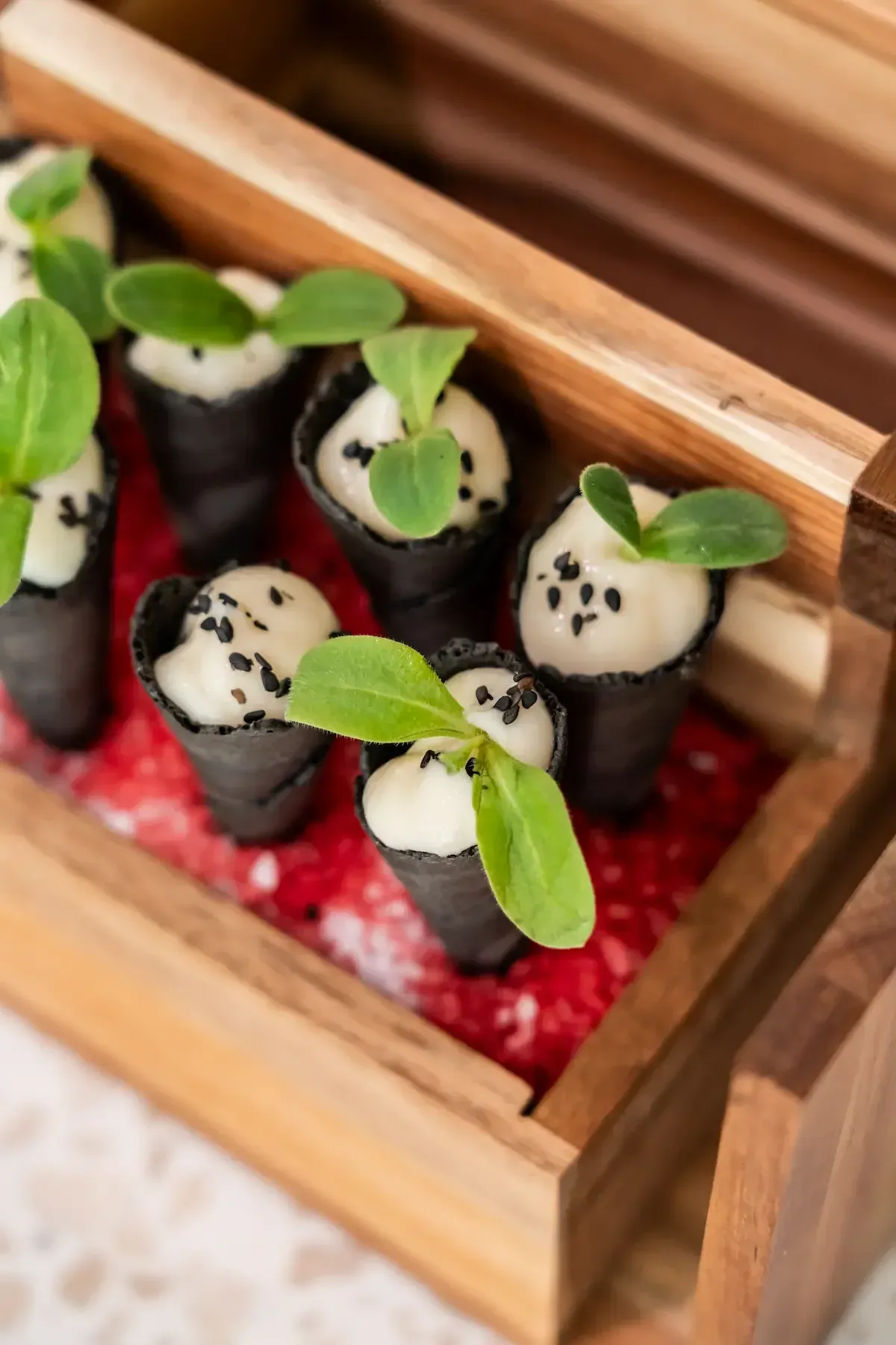 Cannoli van houtskooldeeg gevuld met bloemkoolcrème en sesam