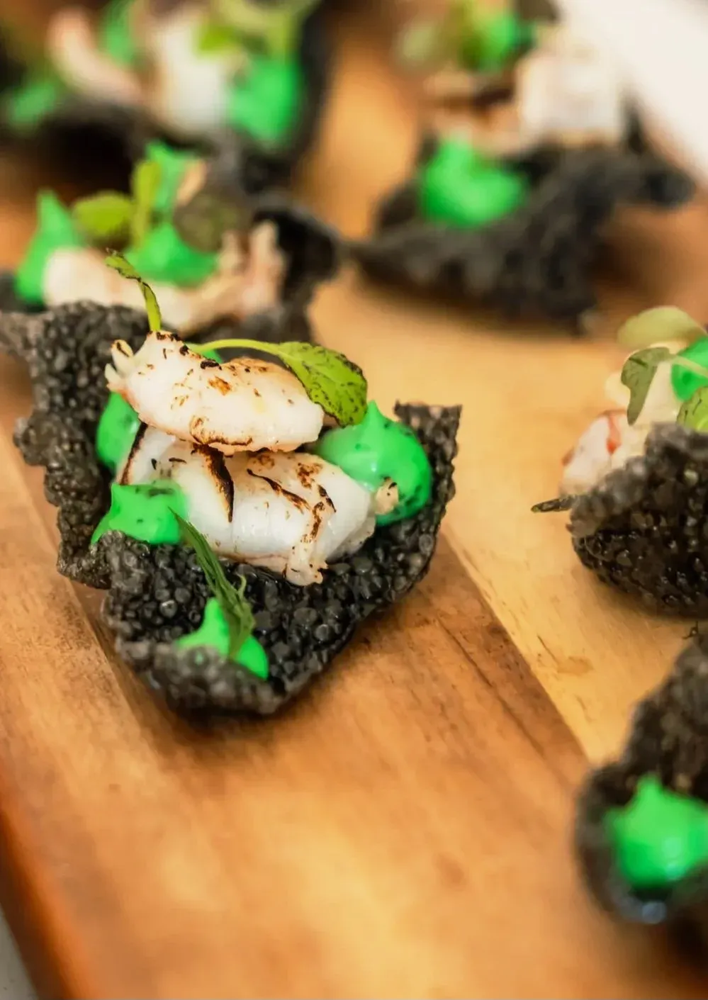 Gebrande gamba op een houtskoolcracker met kruidenolie