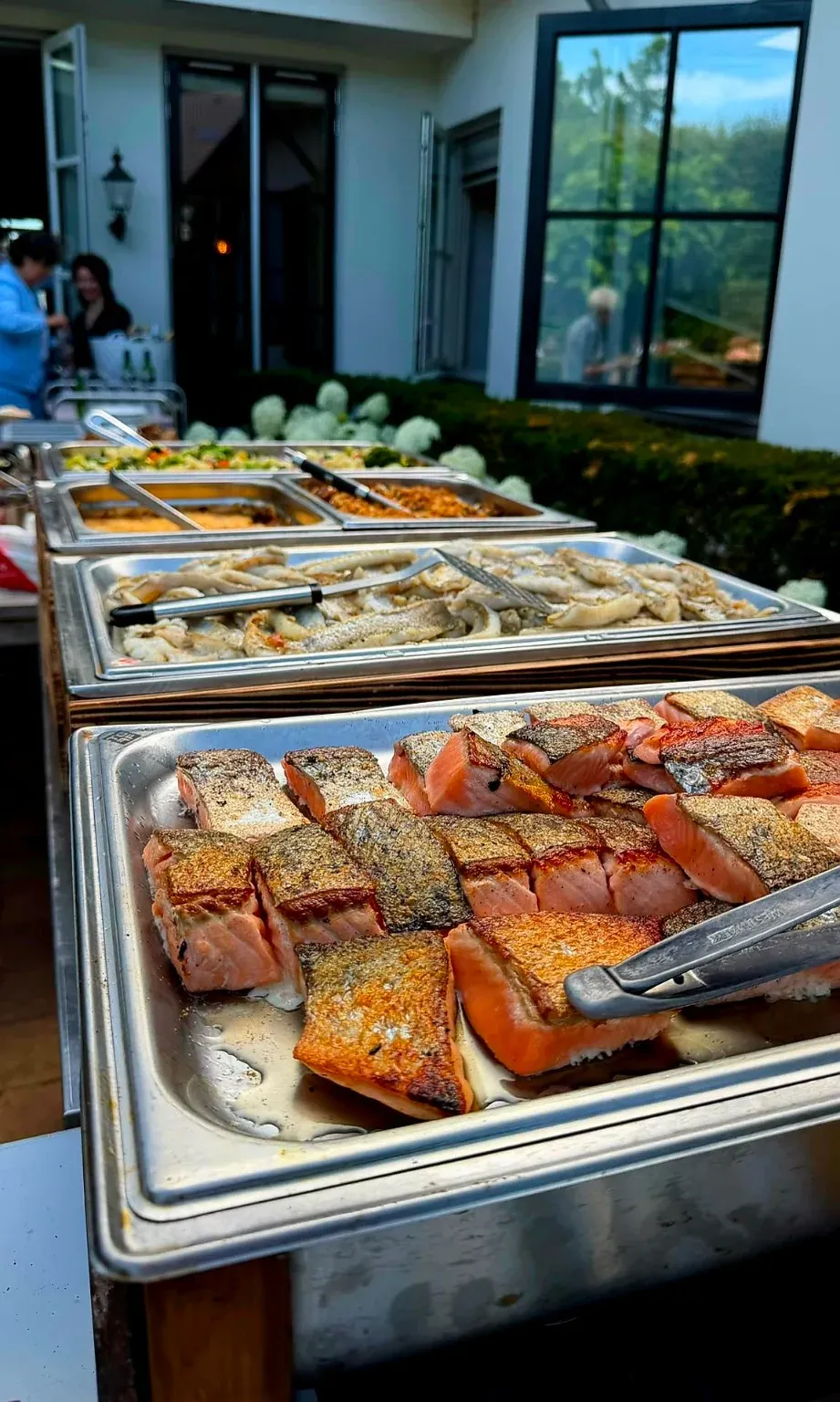 Buffetlijn met zalmmoten met sesamkorst en salades in gastronormbakken