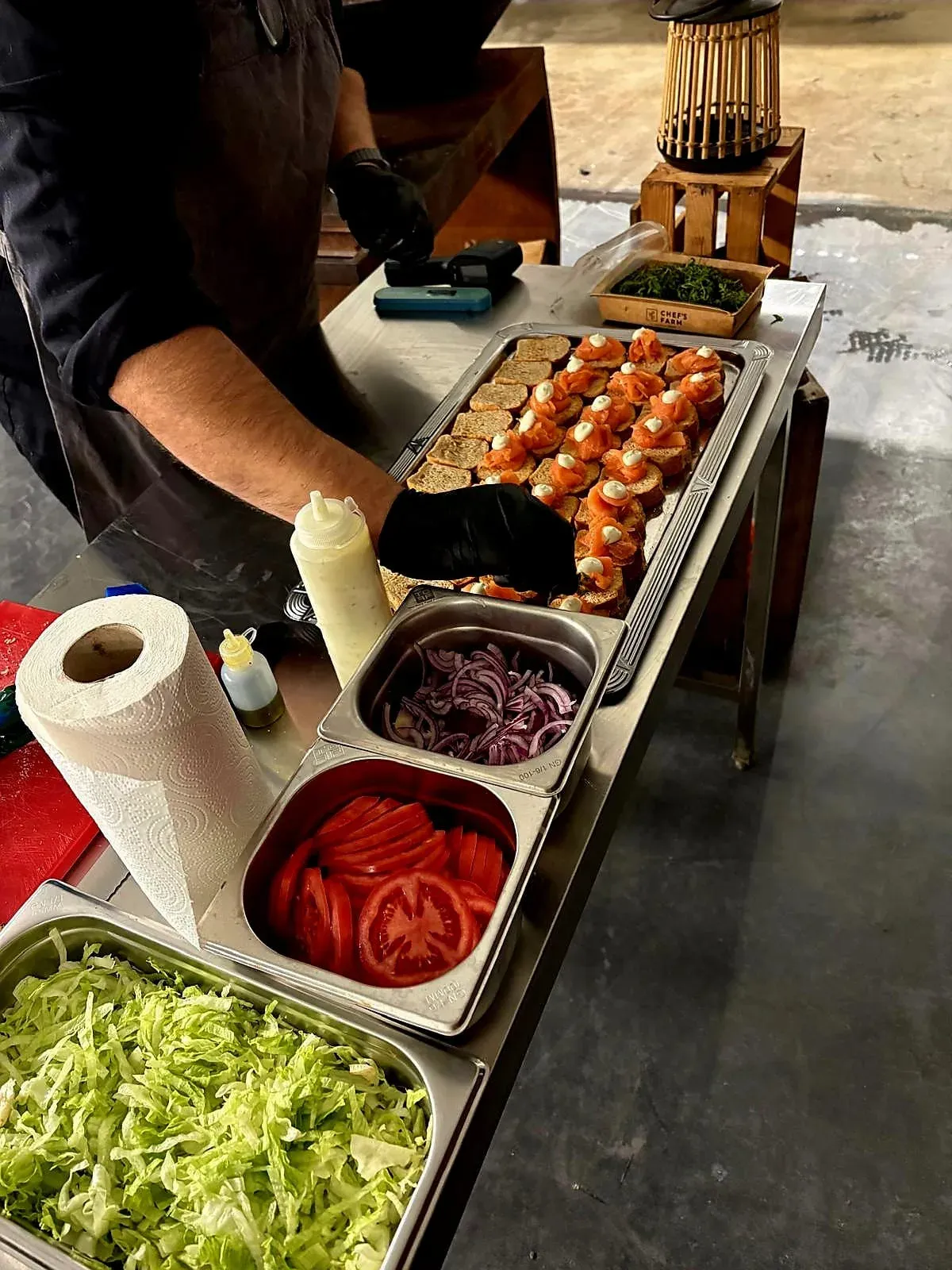 Mise-en-place met spiesen, gamba's, tomaat en uitjes op een steeltafel